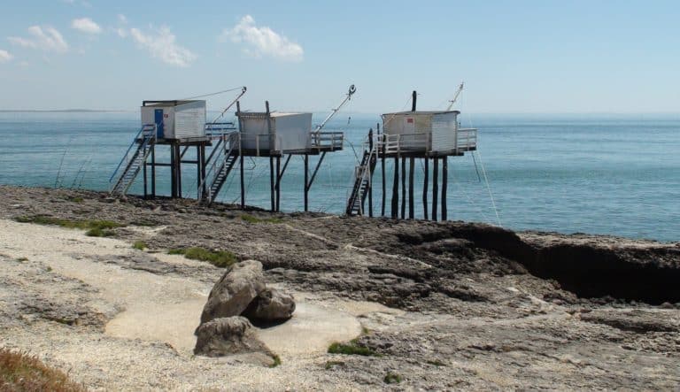 Cabane de pêcheurs sur pilotis en bord de mer.