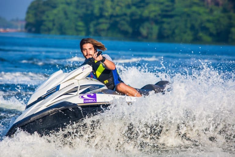 Homme conduisant un jet-ski rapide sur l'eau